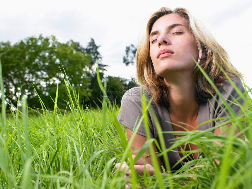 在绿野中放松的女人图片
