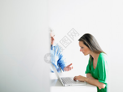 和同事一起在电脑上工作的女人图片