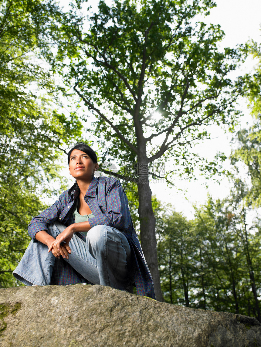 坐在岩石上，树林里的女人图片
