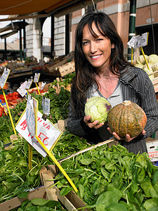 女人在市场上选择蔬菜高清图片