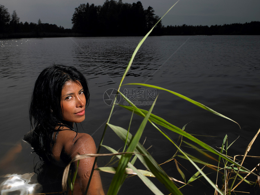 日落时分湖中的女人图片