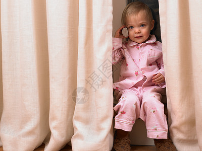 小女孩在窗帘后面打电话图片