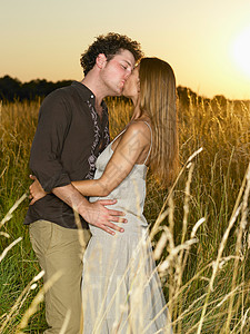 一对在田里接吻的夫妇图片
