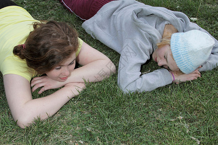 女孩们躺在公园的草地上图片