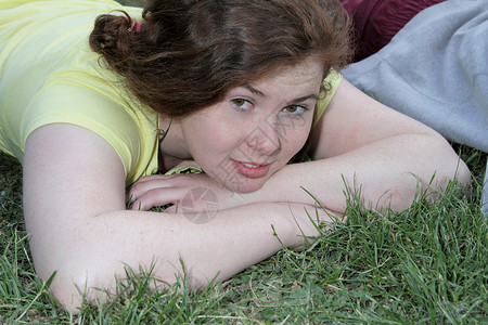 女孩躺在公园的草地上图片