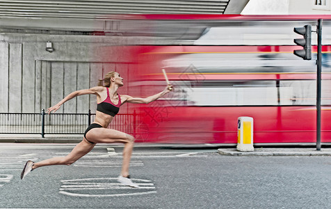 运动员在城市街道接力跑背景图片