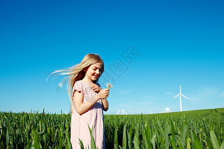有花的女孩站在田野里图片