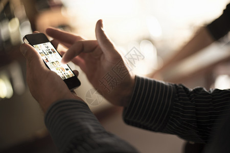 手机后壳酒吧中使用智能手机触摸屏的男子特写镜头背景
