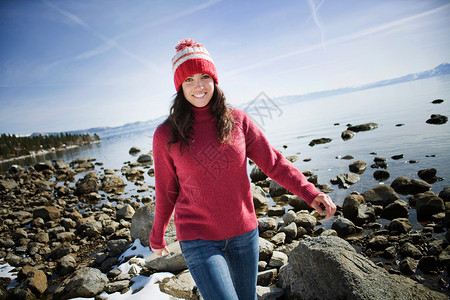 在雪湖附近岩石上行走的女人图片