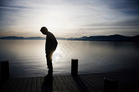思考男人日落时分站在码头上的人背景