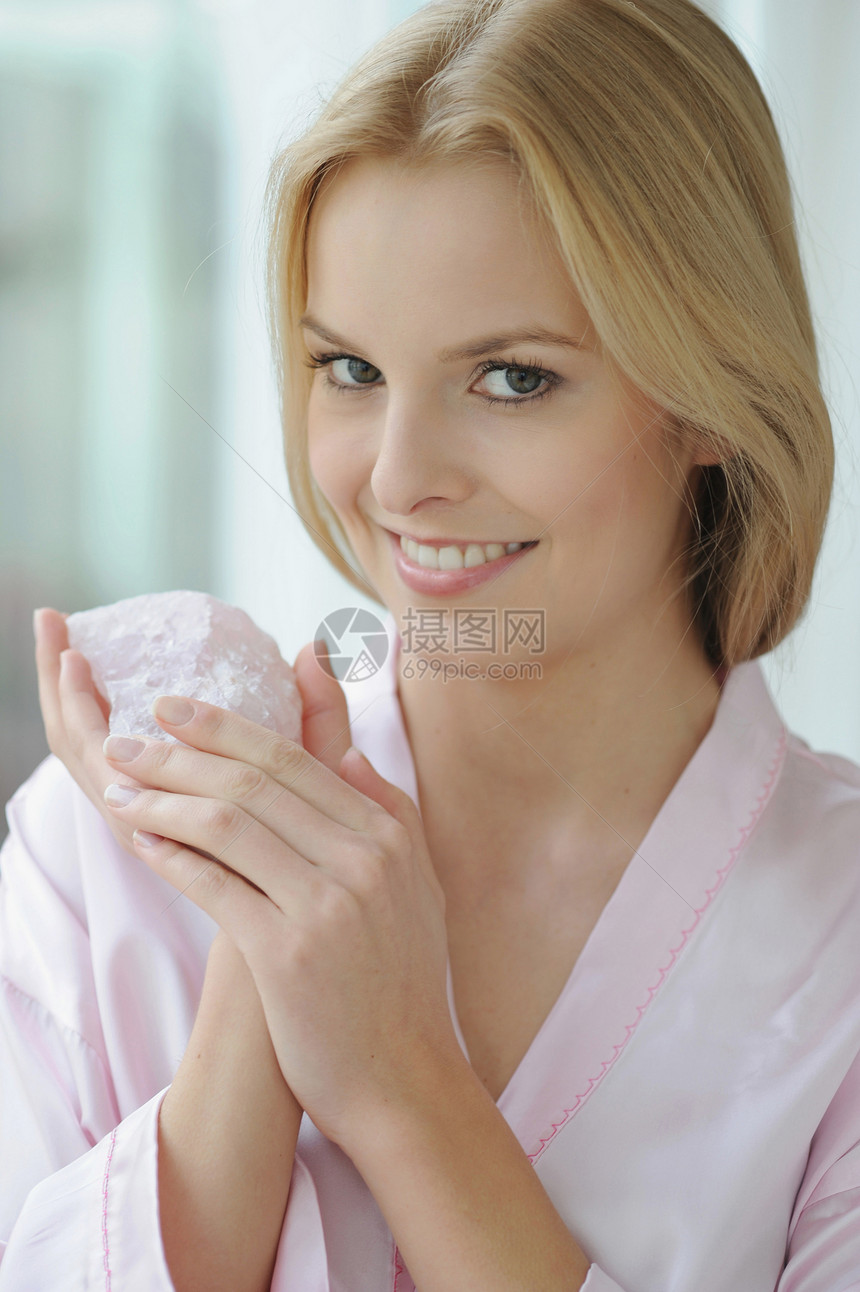 微笑的女人拿着玫瑰石英图片