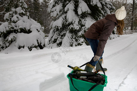 在雪地里拖拽垃圾回收的女人图片