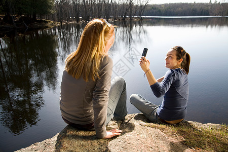 两个女人用电话拍照图片