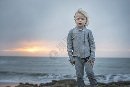 低至五折美国加利福尼亚州卡默尔，日落时微风习习的海岸上男孩的肖像背景