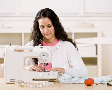 缝纫机素材妇女在家使用缝纫机背景