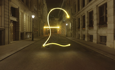 分享赚钱素材英国伦敦下夜幕中城市街道上闪亮的英镑符号背景