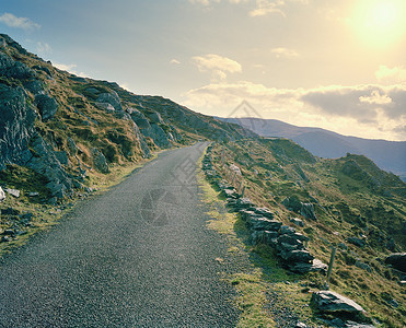 崎岖不平的道路在山坡上铺设的乡村道路背景