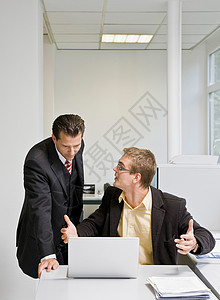 老板和同事一起看笔记本电脑背景图片