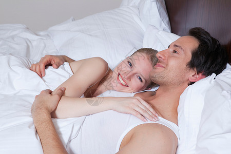 夫妻在床上笑着说话图片