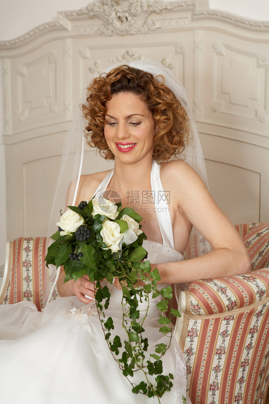 年轻的新娘微笑着看花图片