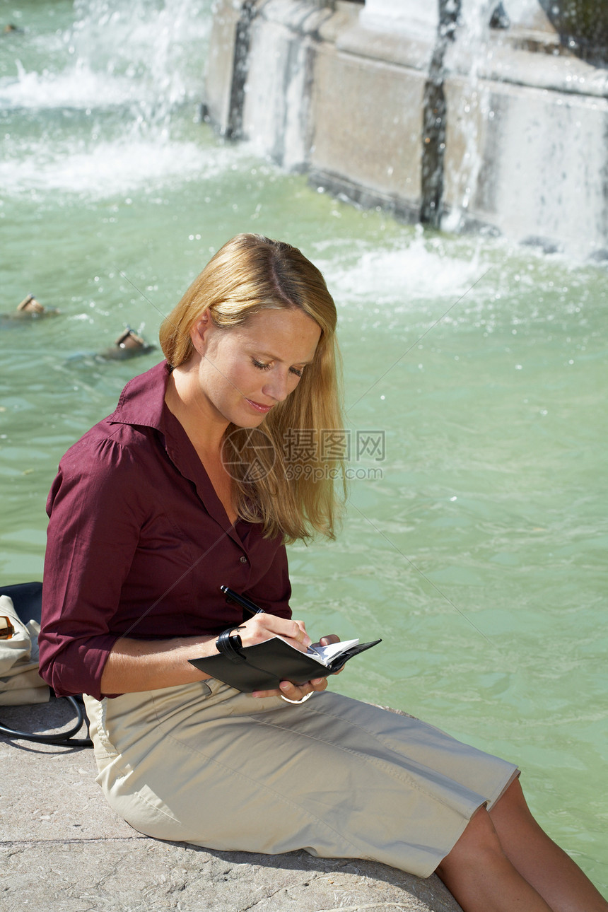 坐在喷泉上的女商人图片