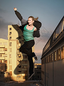 女人在大楼旁跳跃图片