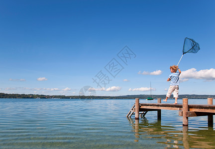 男孩在湖中捕鱼高清图片