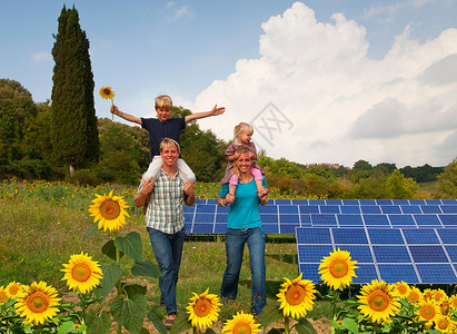 在太阳能电池板傍边的一家人高清图片
