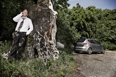 专插本一名男子靠在树上背景