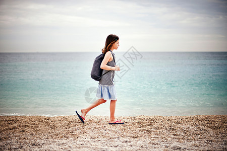 瓦砾滩在海边散步的女孩背景