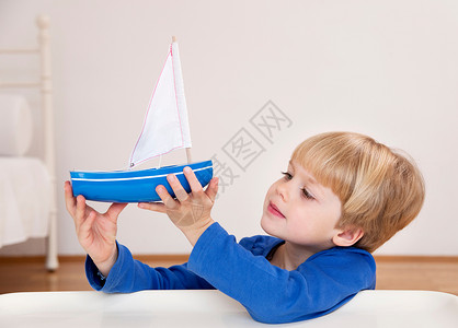 小男孩与帆船男孩玩玩具船背景