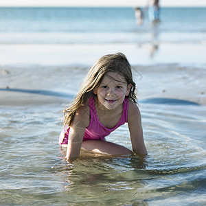海滩上在水里玩耍的女孩图片