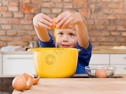 男孩在碗里加鸡蛋图片