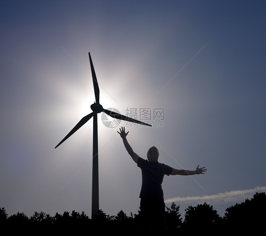 在太阳和风力涡轮机上举起手臂图片