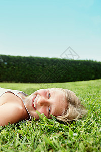 躺在草地上微笑的女孩图片