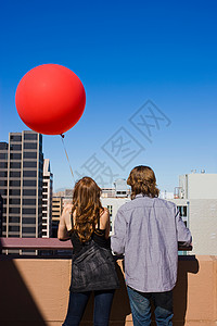 气球屋屋顶上的朋友带着红色气球背景