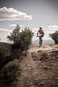 崎岖小路上的山地自行车手背景图片