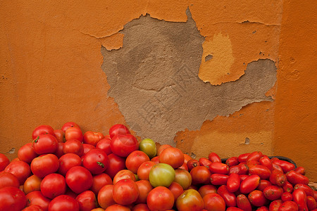 番茄堆在混凝土墙上图片
