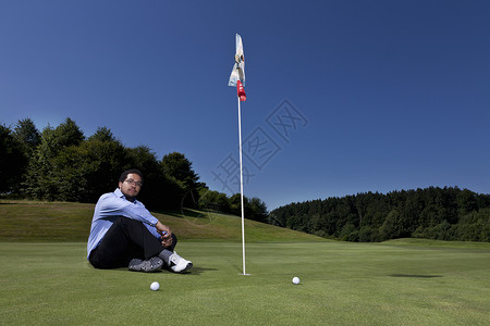 坐在高尔夫旗旁图片