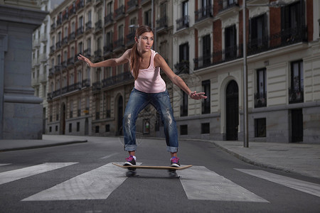 在城市街道上玩滑板的女人图片