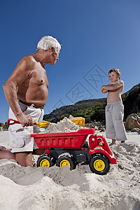 在海滩上和孙子玩的男人高清图片