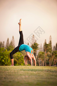 在草地上练习瑜伽的女人高清图片