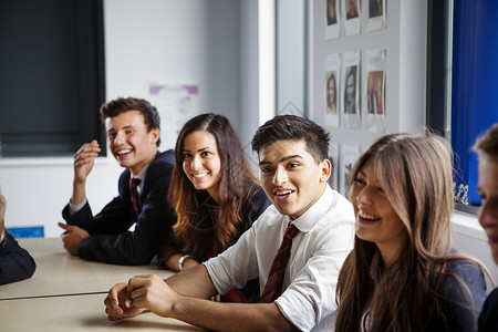 种族多样性坐在教室课桌旁的青少年学生背景