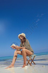 在海滩上看书的女人图片