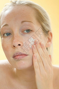 女人在脸上擦润肤霜图片