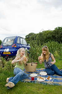 年轻女子在车前吃东西高清图片