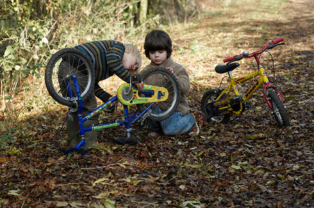 两个男孩检查自行车图片