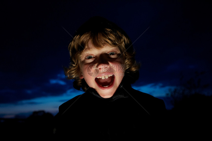 男孩用手电筒做鬼脸图片