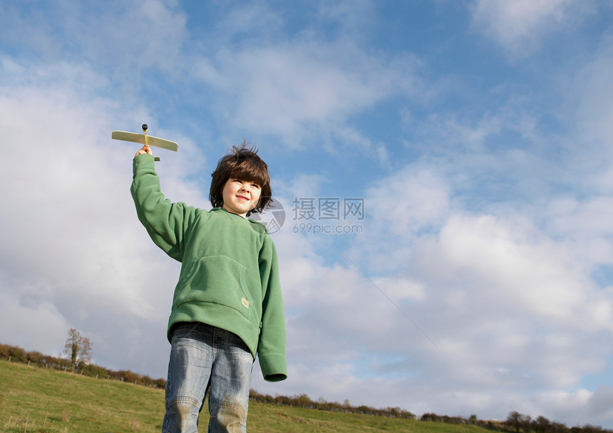 在田里玩玩具飞机的小男孩图片