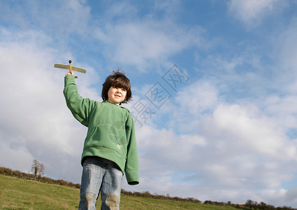 在田里玩玩具飞机的小男孩图片